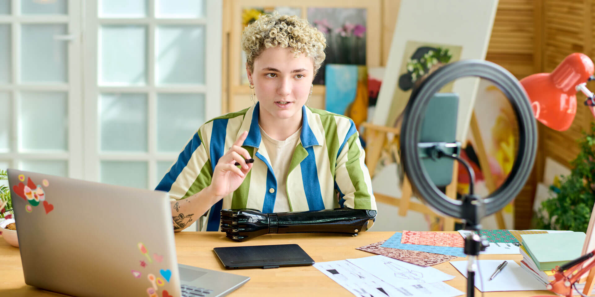 Young confident female blogger giving masterclass or training to online audience while sitting in front of smartphone camera at home